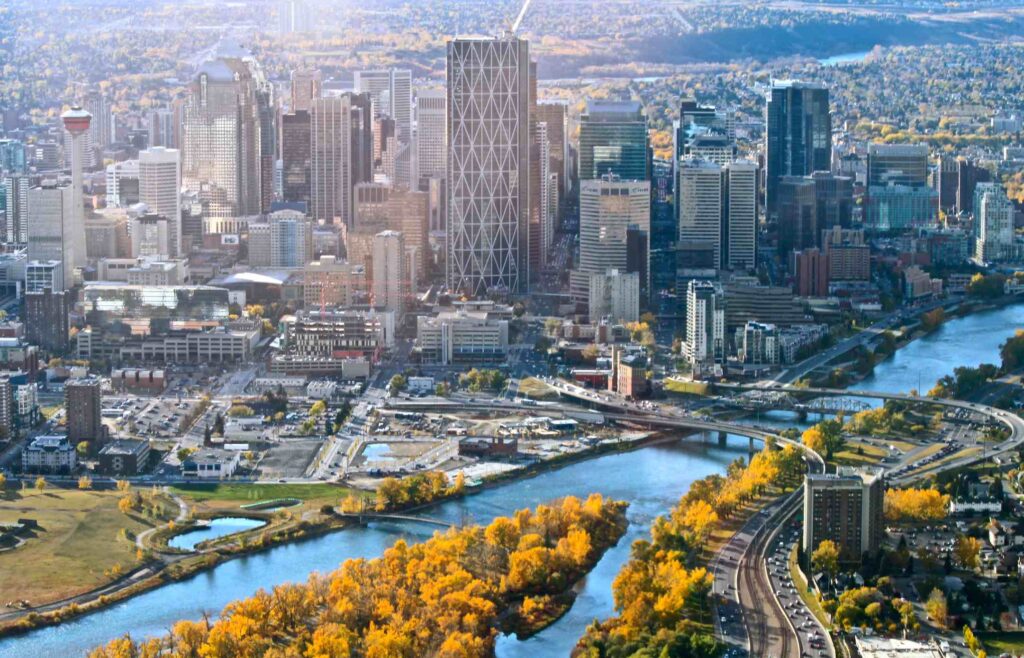 Aerial view of downtown Calgary and the Bow River lined with autumn trees