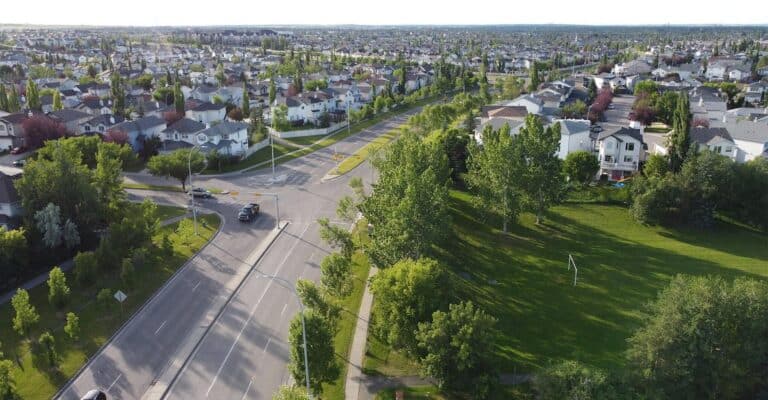 Aerial view of a green Calgary suburb with tree lined streets in summer