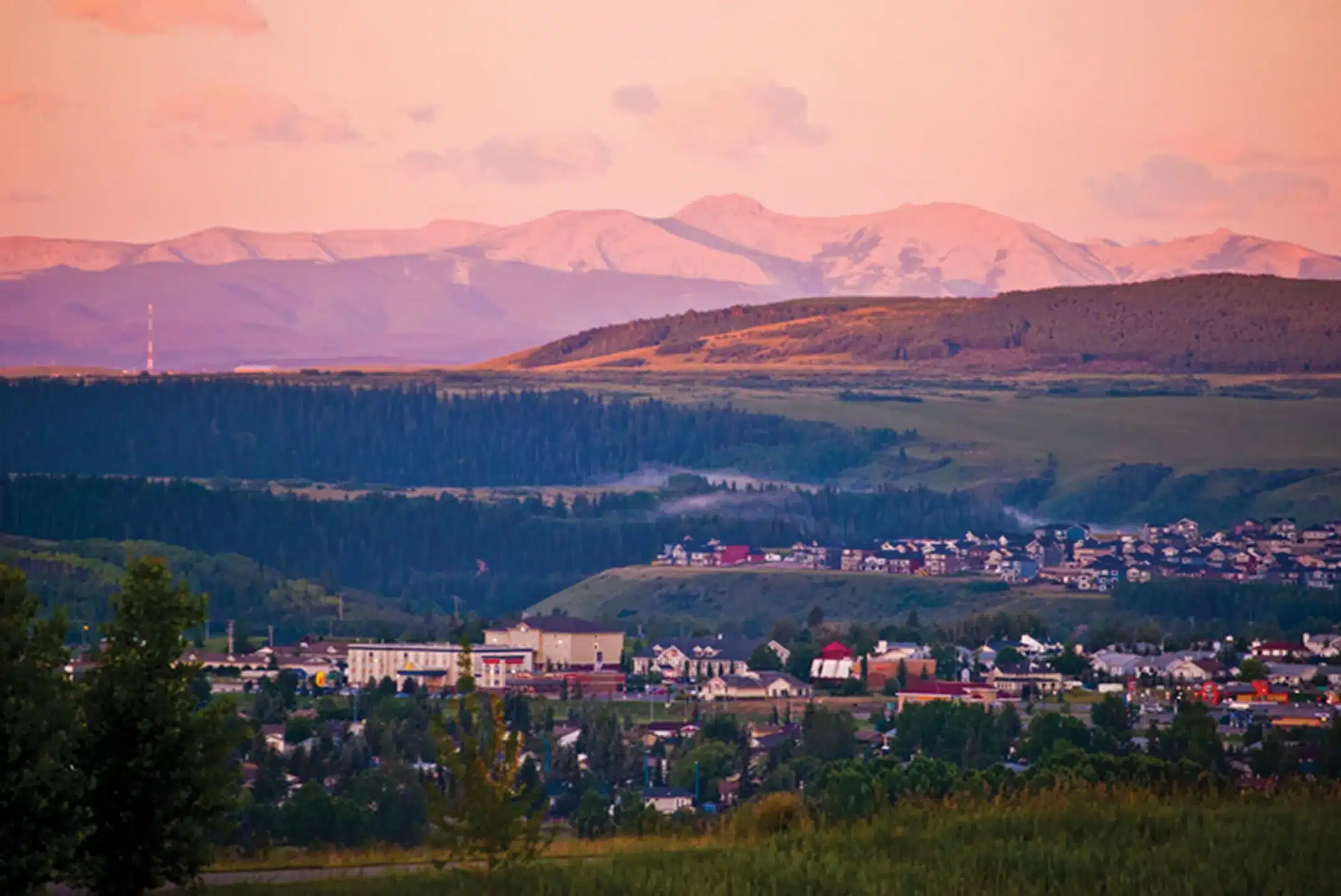 Cochrane, Alberta at sunset, homes in the Bow Valley with the Rocky Mountain foothills behind